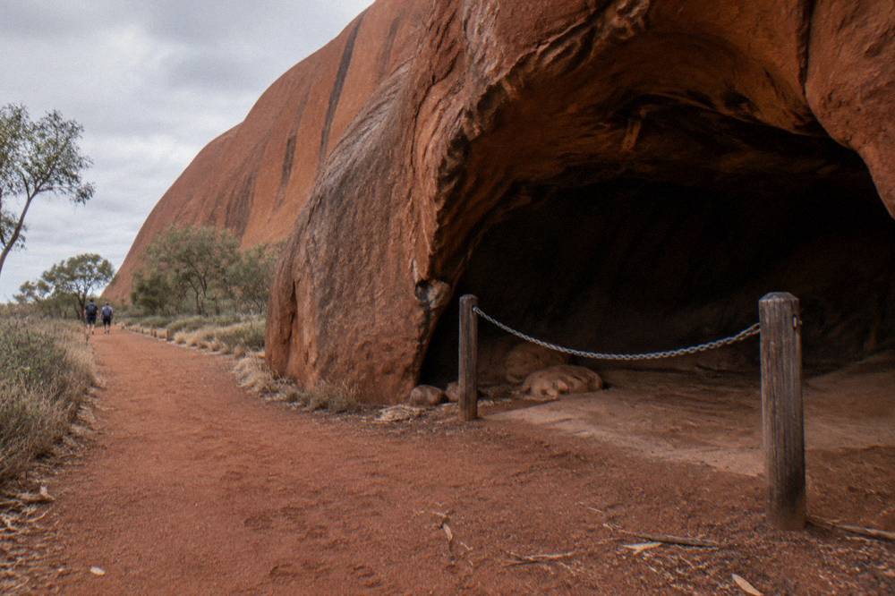 A sign beside a walking path at the base of Uluru marking a culturally sensitive area