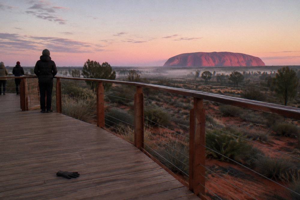 A wide desert sunrise viewing platform looking toward Uluru in the distance