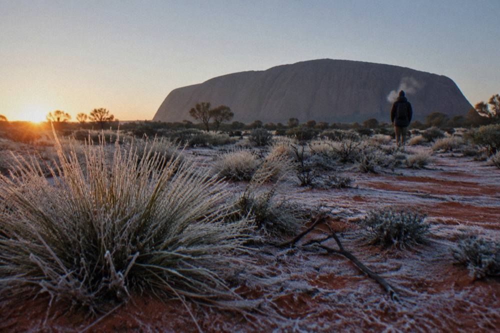 Frost-covered red sand and spinifex near Uluru on a cold clear winter morning