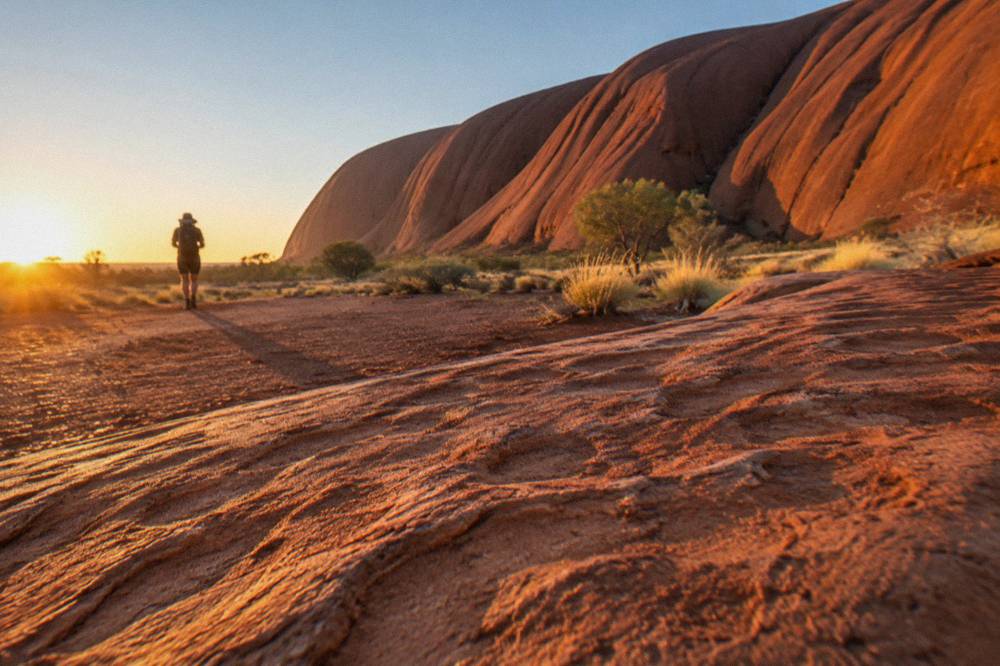 Morning light falling across the rippled sandstone walls near the base of Uluru