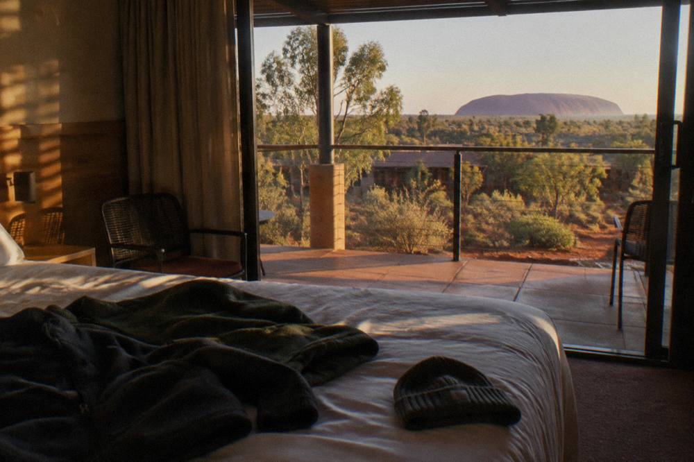 Warm jackets and hats laid out on a hotel bed before an evening desert outing