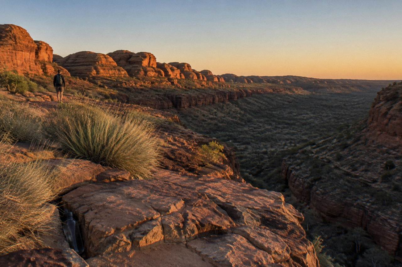 Red rock domes of Kings Canyon glowing under a wide desert sky at sunrise