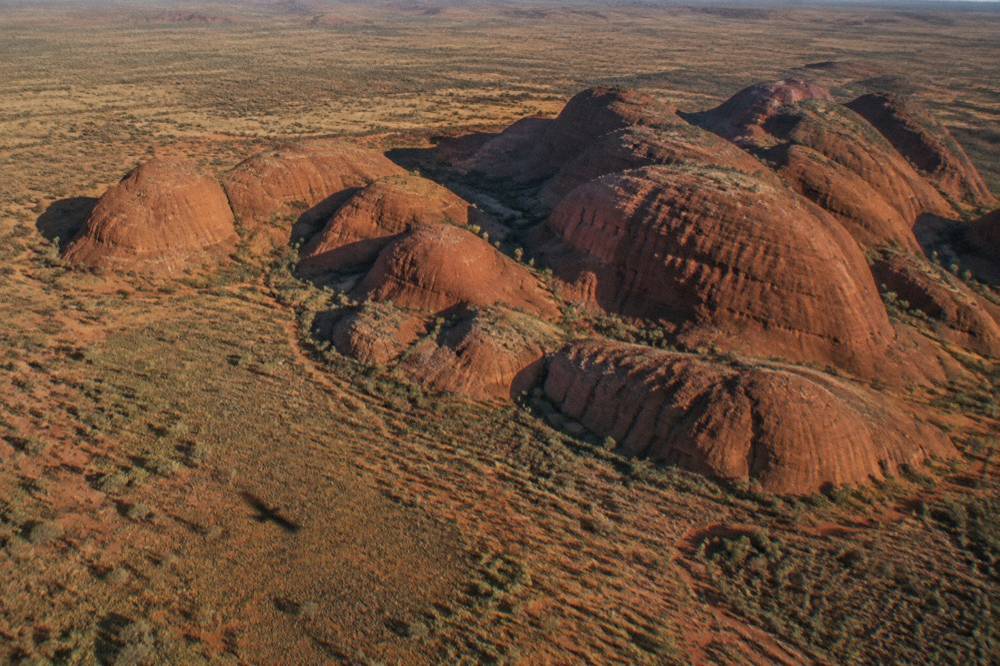 The domes of Kata Tjuta seen from above with shadows crossing the red rock formations