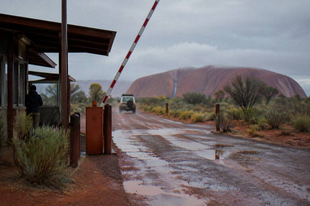 A park entry station gate on a desert road with clear signage under morning light