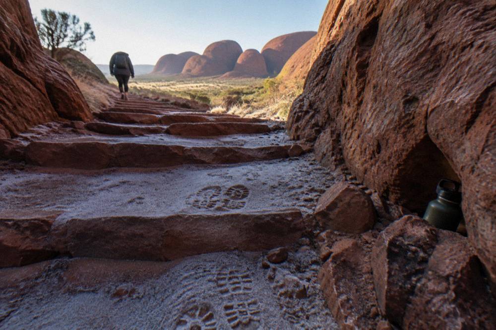 Steep stone steps cut into red rock leading up between two tall cliff faces
